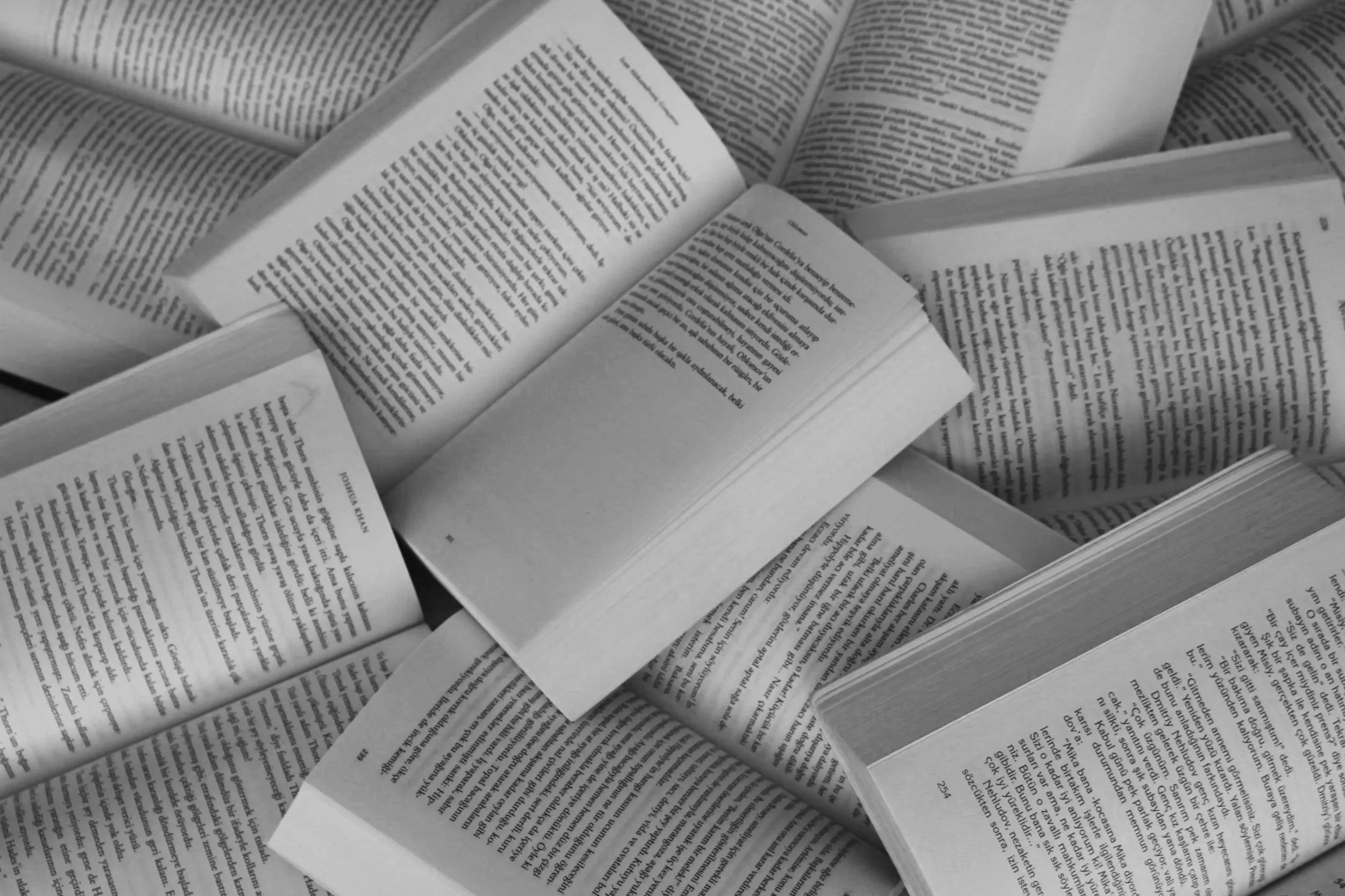 Mehrere offene Bücher und Zeitschriften, auf einem Tisch verteilt.