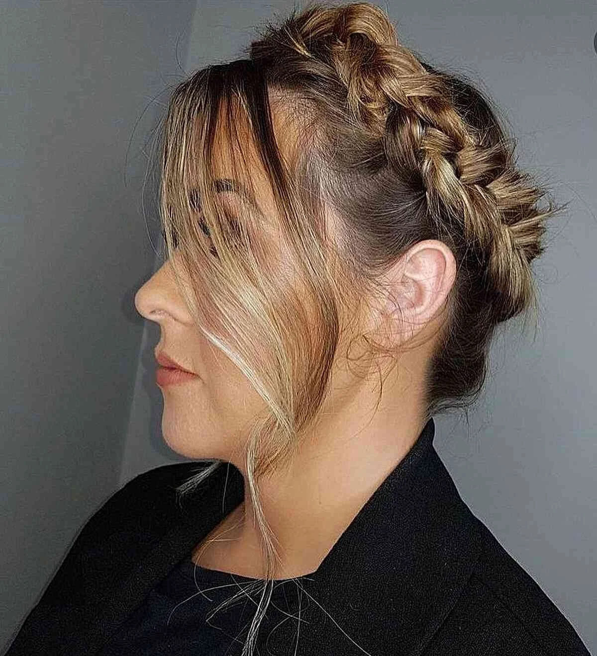 Side profile of a woman with blonde-gray hair styled in a halo braid.