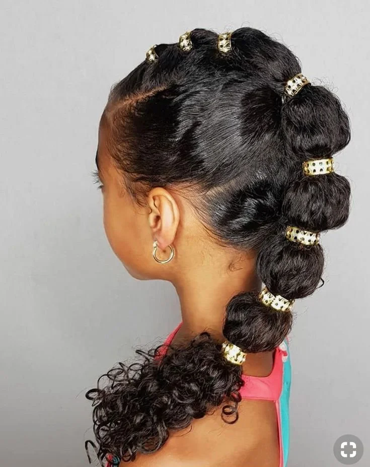 Side profile of a young girl wearing a long bubble braid.
