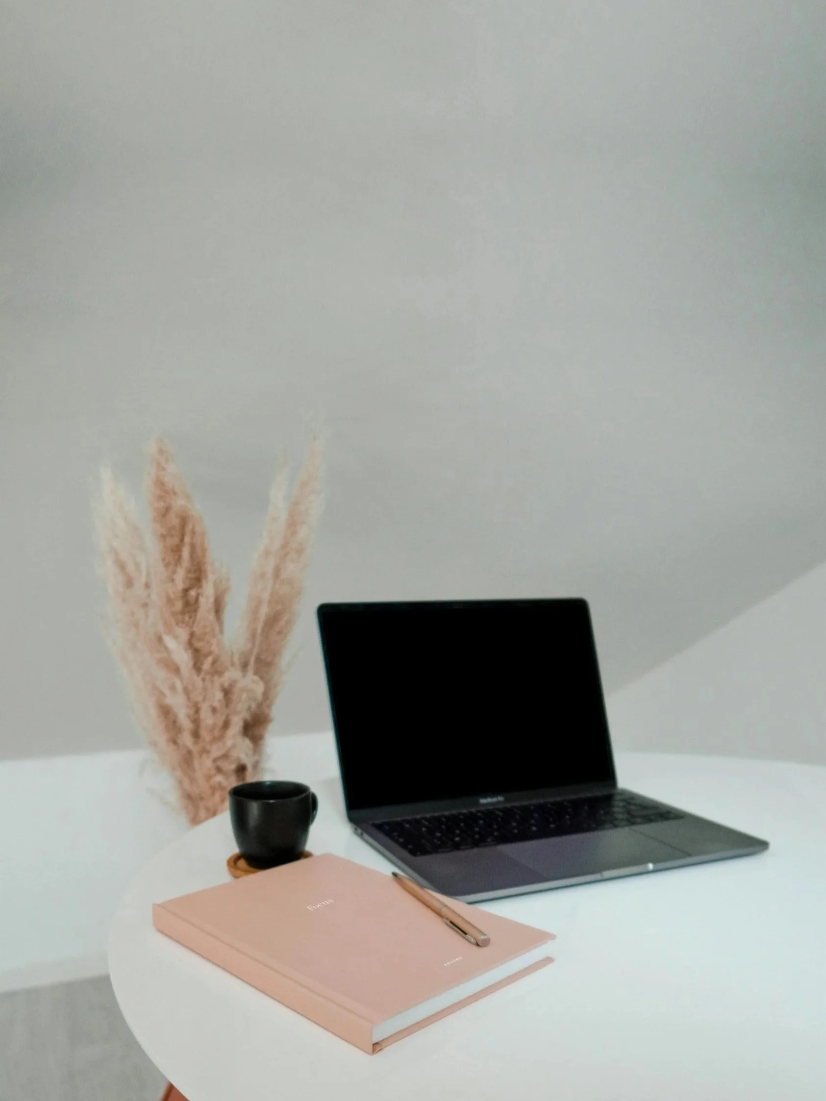 Workspace with laptop, planner and notebook, representing focused thinking, planning, taking action