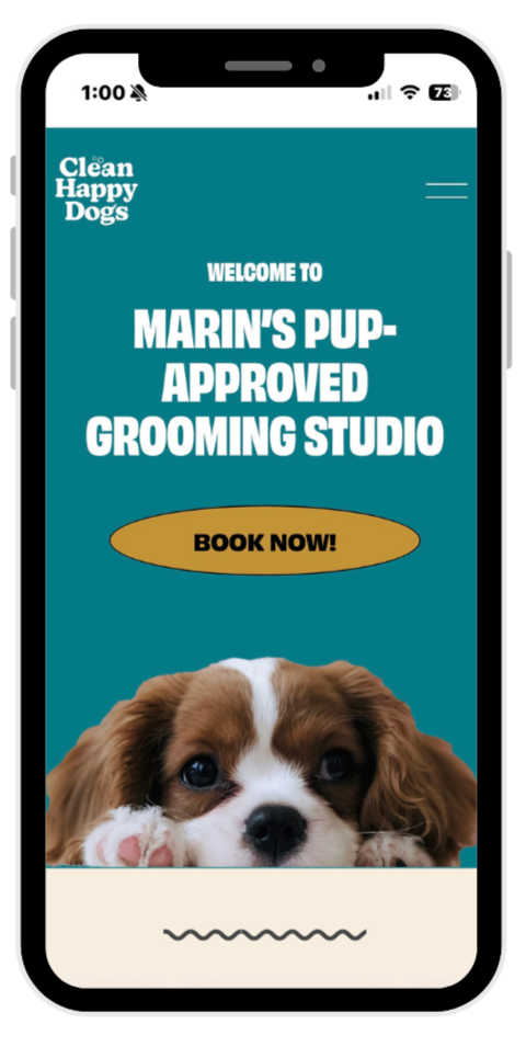 A smartphone displaying a website for a dog grooming studio called 'Clean Happy Dogs'. The page includes a welcome message for Marin's Pup-Approved Grooming Studio with a button labeled 'Book Now!' and a picture of a puppy at the bottom.