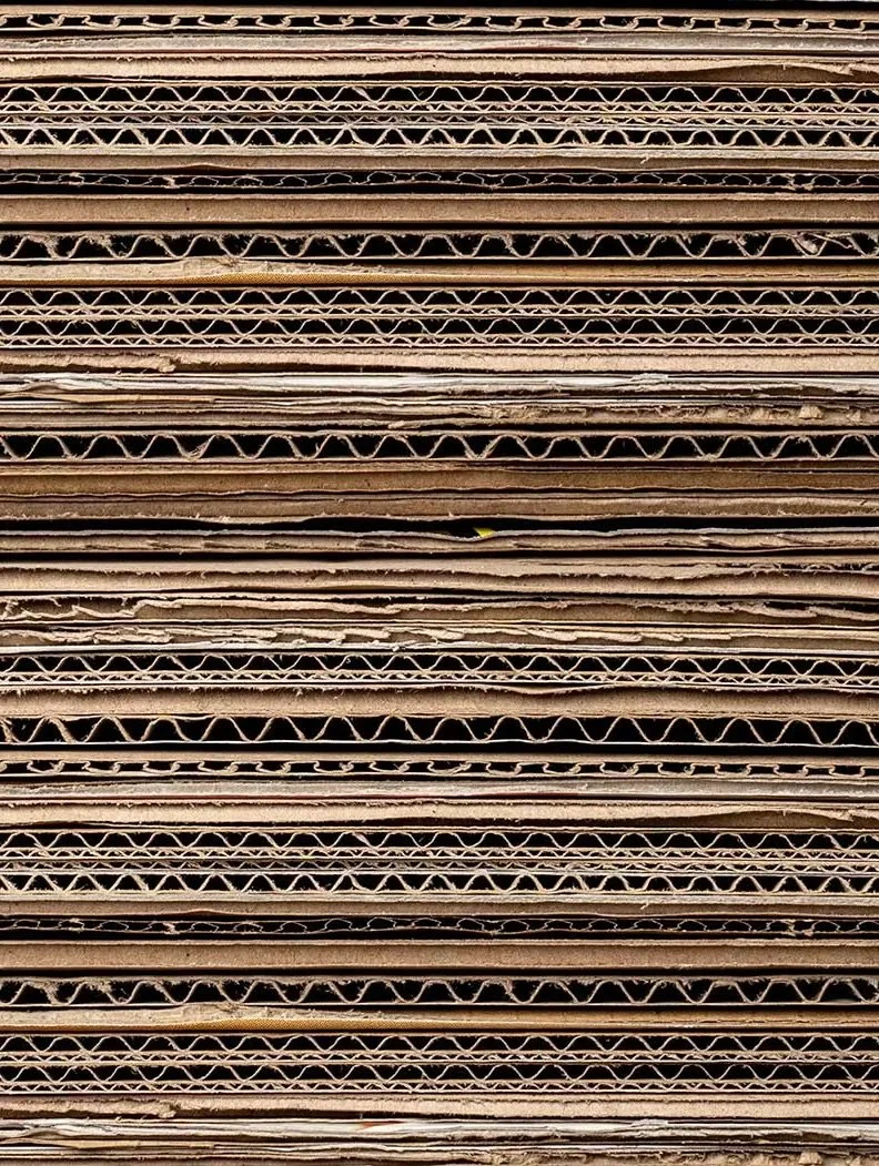 Stacked corrugated cardboard pieces.