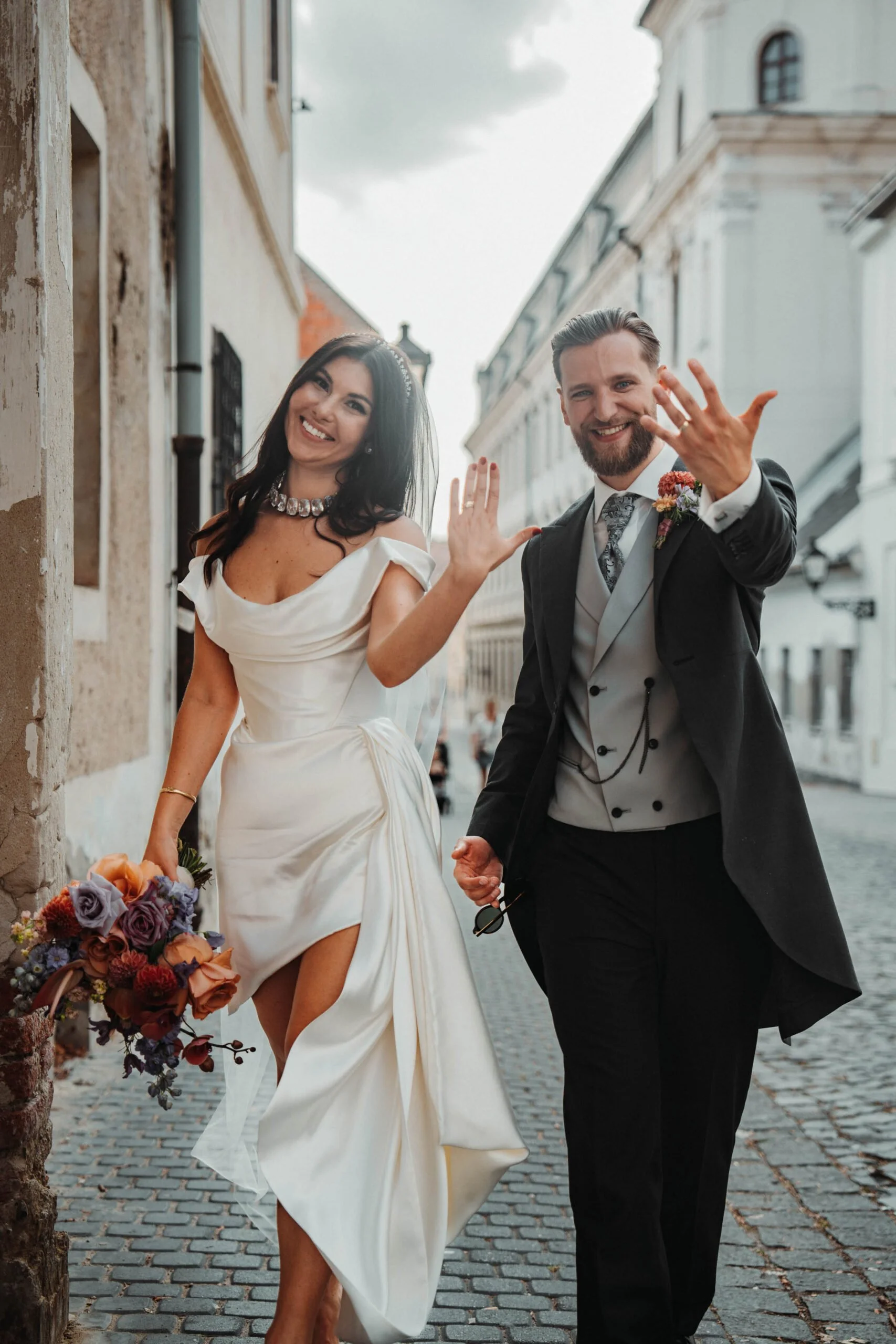 Nevesta a ženích kráčajú uličkou starého mesta v Trnave.