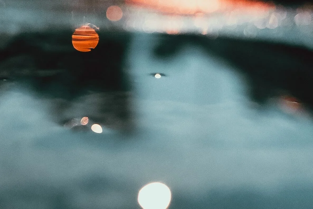 Abstract water reflection with blurred lights and colors.