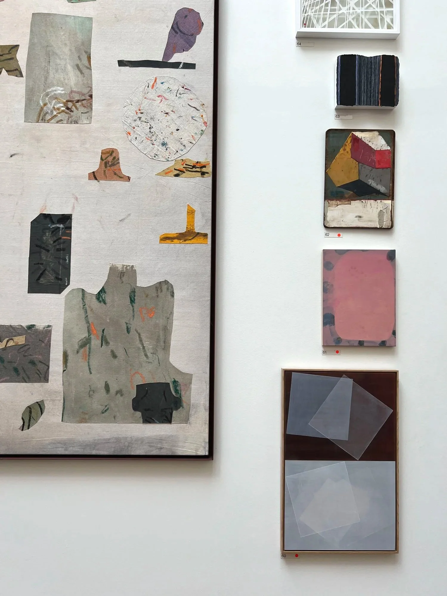 Gallery wall displaying an abstract collage painting and numbered abstract artworks in varied geometric and textured styles.