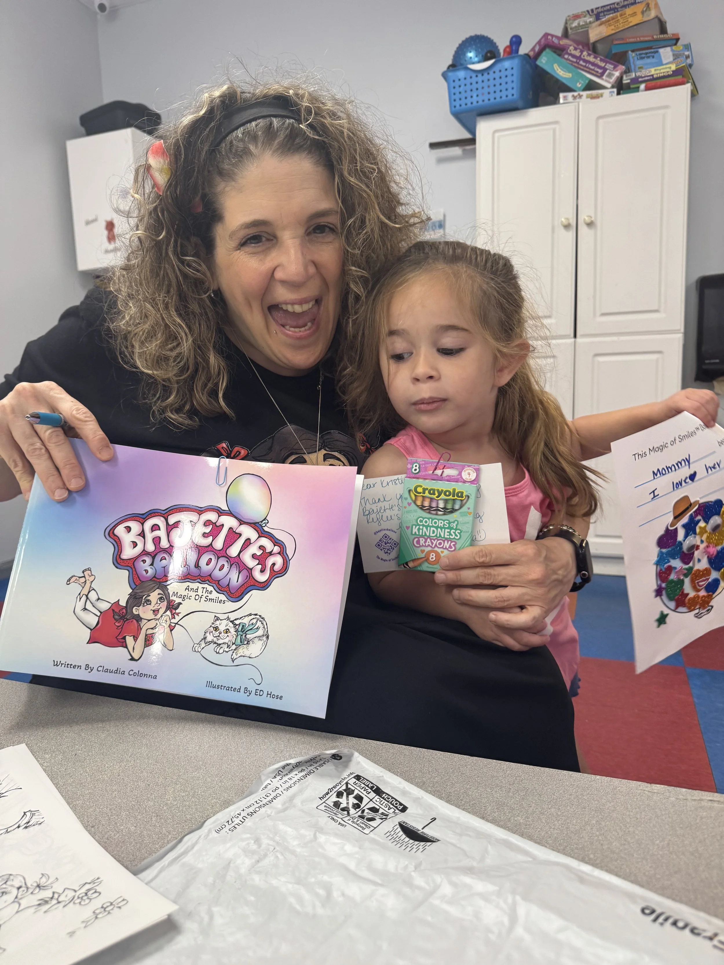 Claudia Colonna, author of children's book "Bajette's Ballon" pictured with child during her Magic of Smiles book tour.