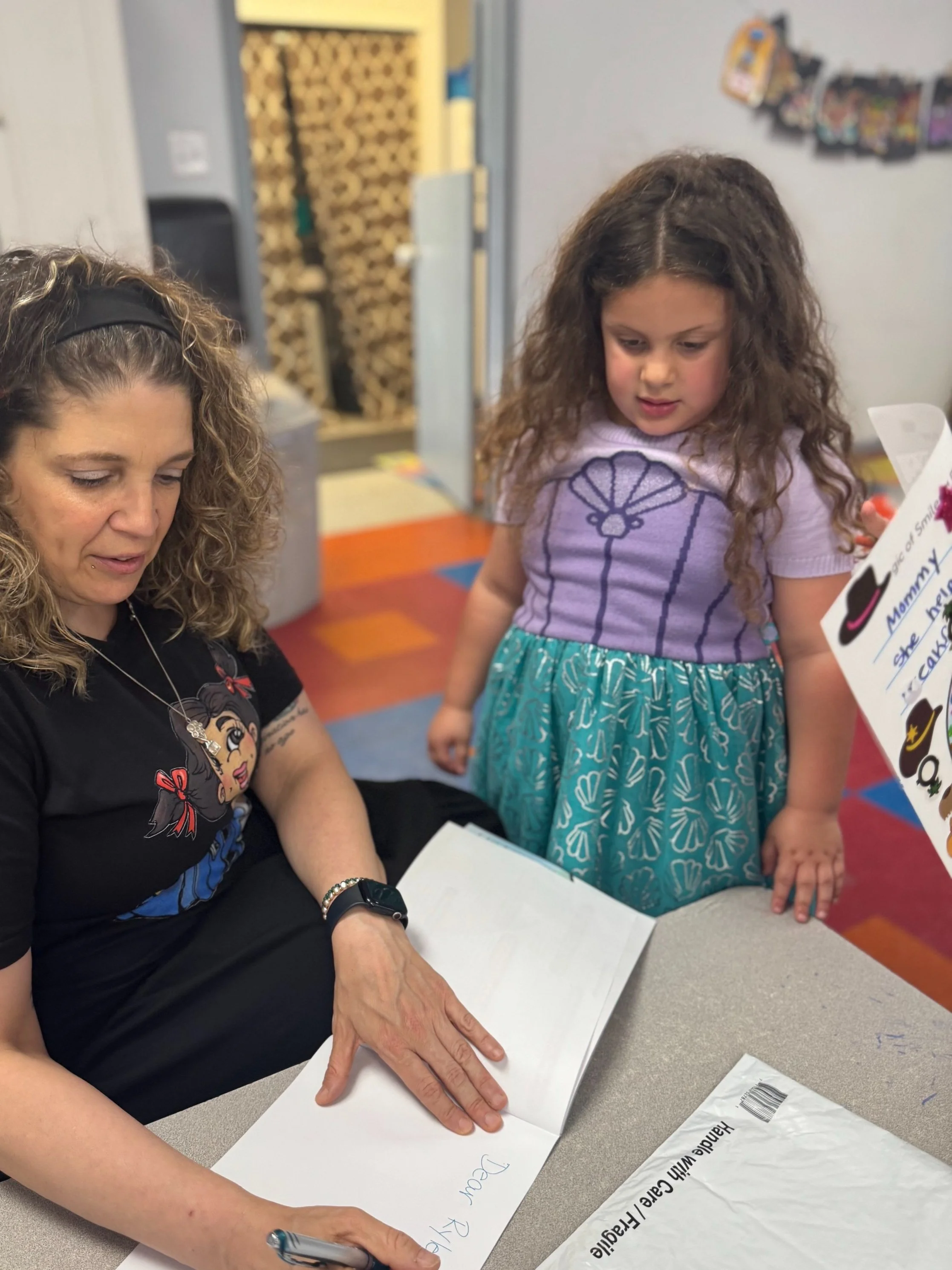Claudia Colonna, author of children's book "Bajette's Ballon" pictured with child during her Magic of Smiles book tour.