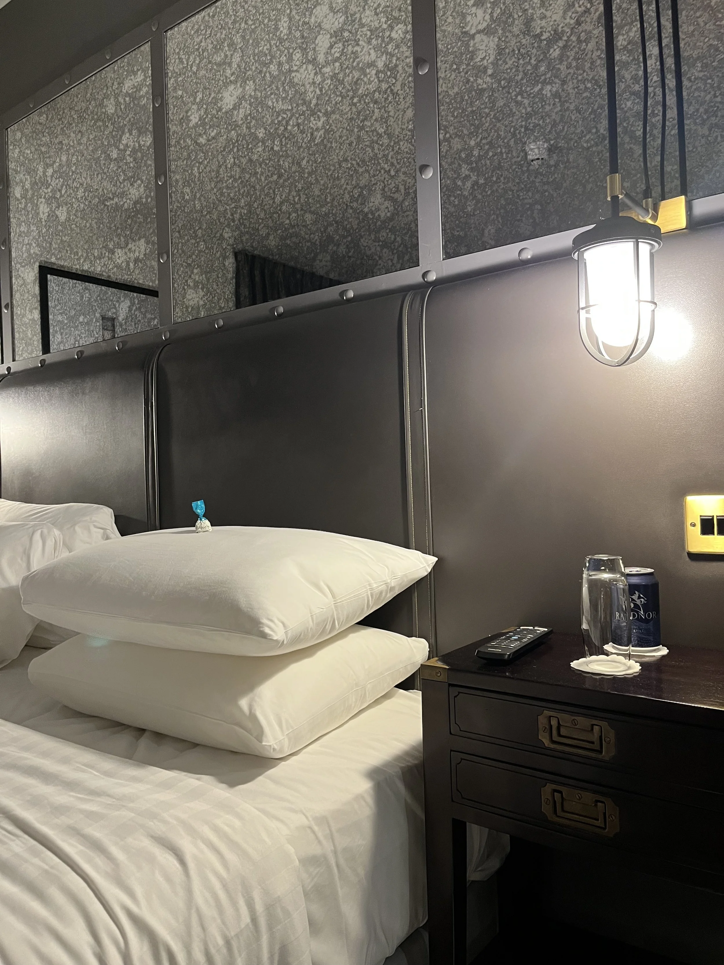 La chambre supérieure du Titanic Hôtel Blefast avec un lit queen size et une tête de lit au style croisière.