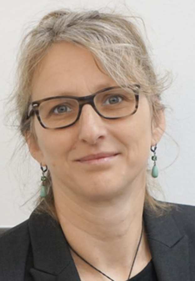A woman with blonde hair, glasses, and turquoise earrings smiling at the camera.
