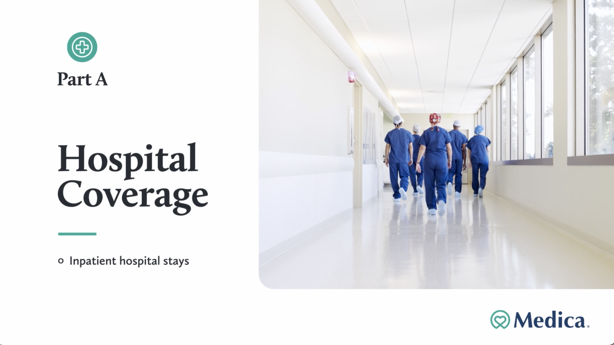 Hospital hallway with healthcare workers walking away, wearing scrubs and hair covers, with large windows on the right side.