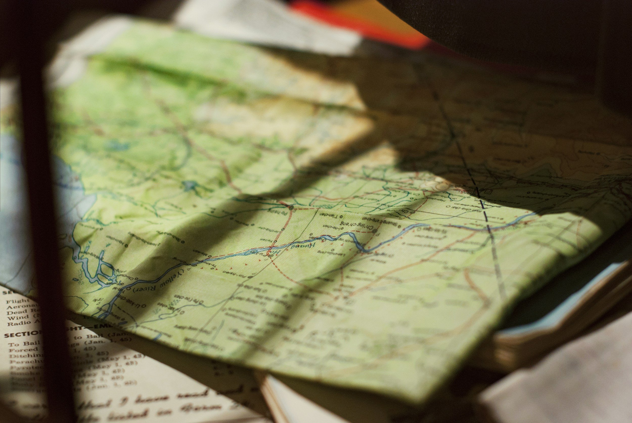 Folded road map resting on household planning papers.