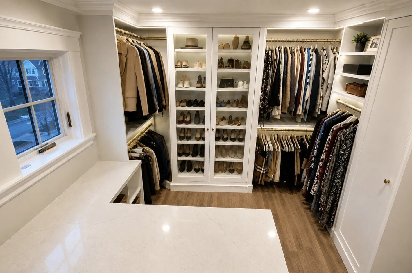 A walk-in closet with organized clothing, shoes, and accessories, featuring built-in shelves, hanging rods, and a window.