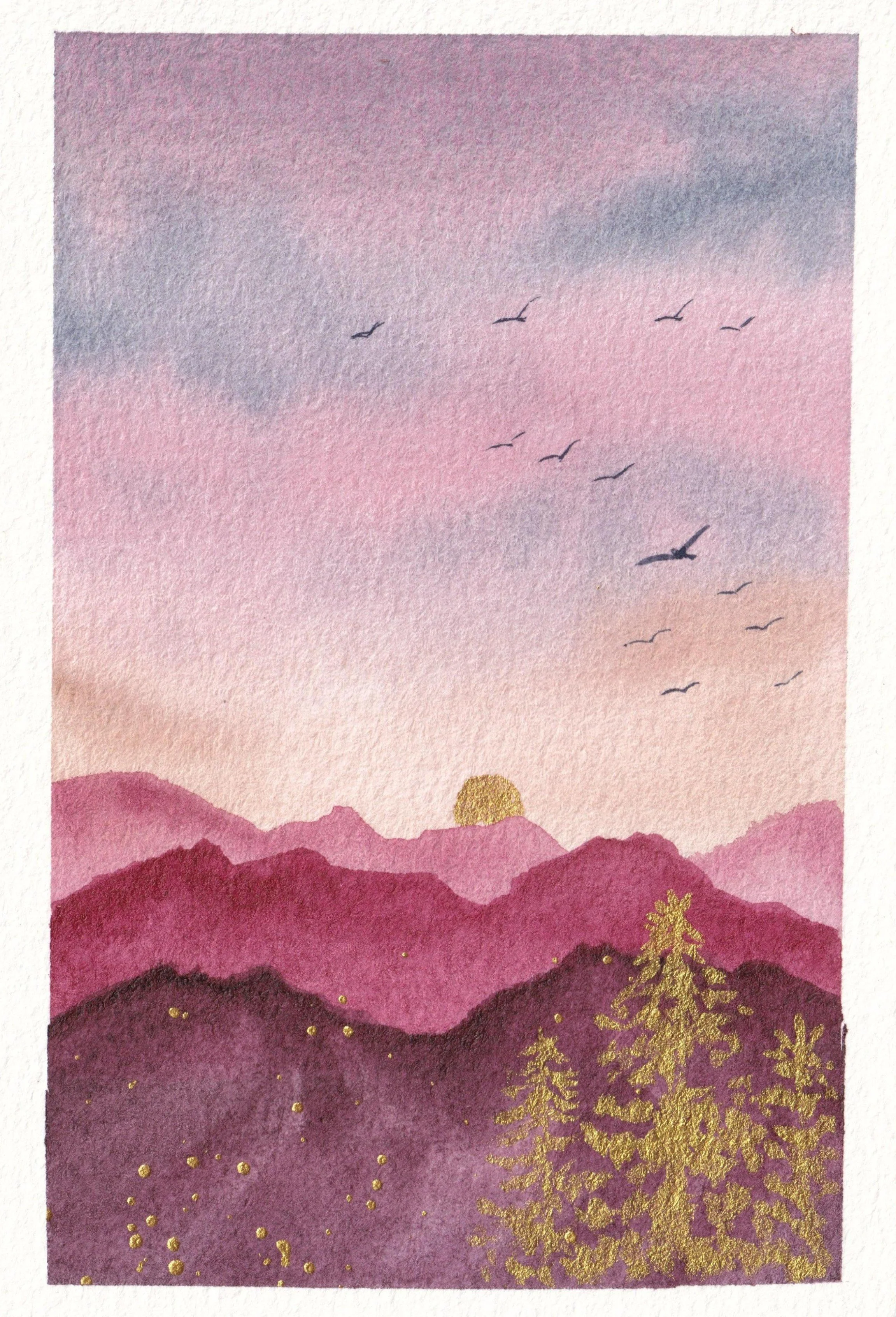 A watercolor painting of a sunset over mountains with birds flying in the sky, decorated with gold flecks and trees in the foreground.
