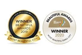 Two award badges, one from 2019 for Most Beautiful City and one from 2020 for Most Beautiful Small City, New Zealand