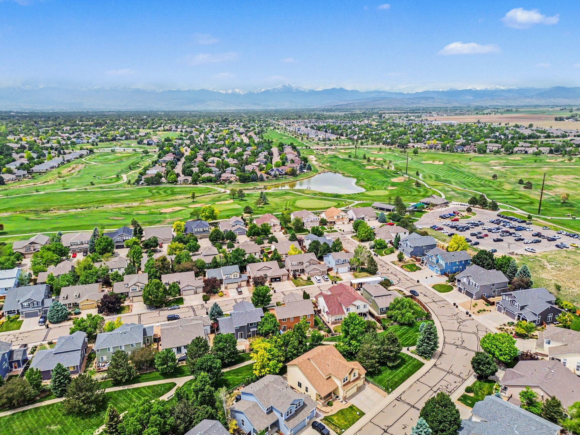 Northern Colorado neighborhood with golf course, pond, and Front Range mountain views