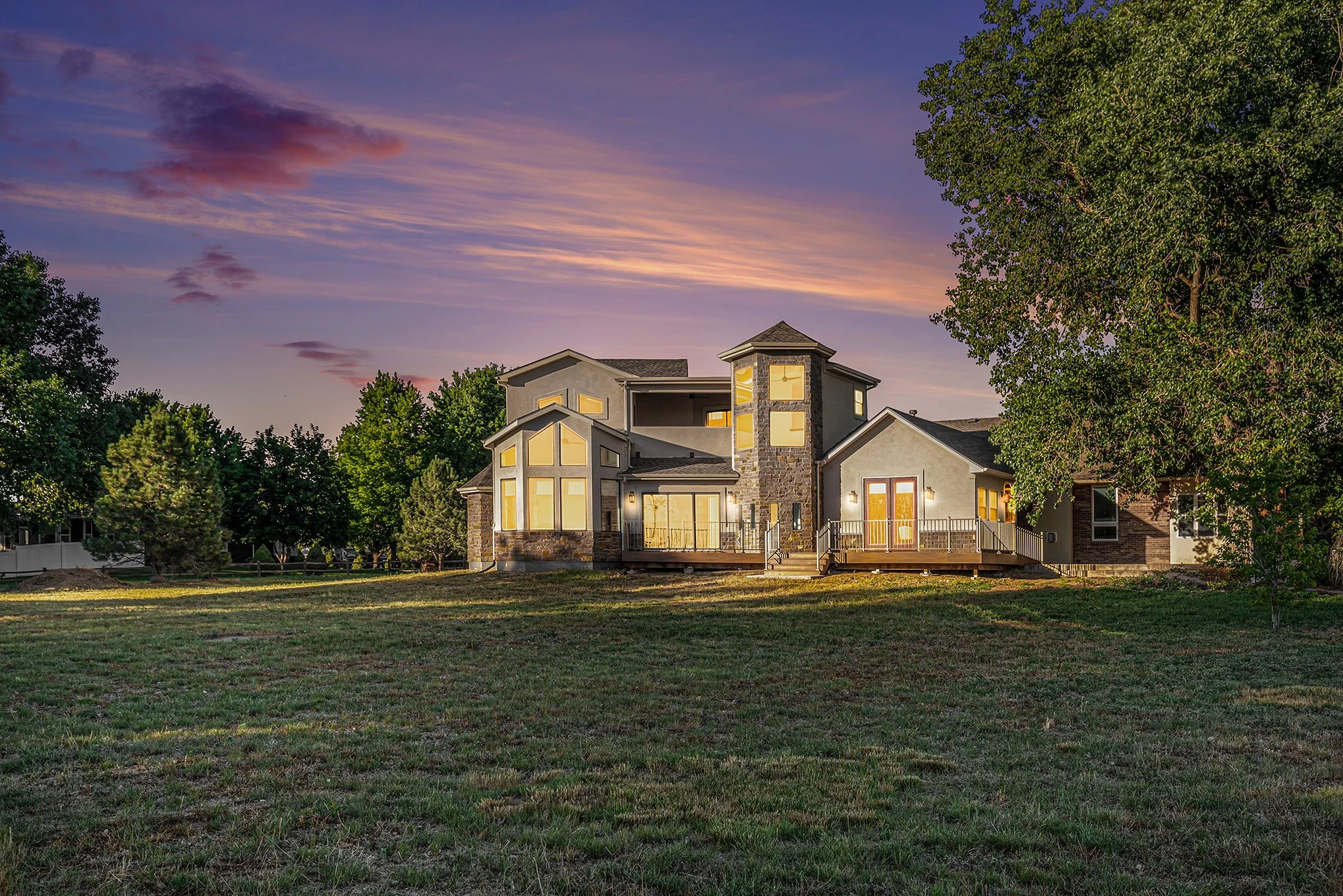 Northern Colorado home at sunset with mature trees and mountain views