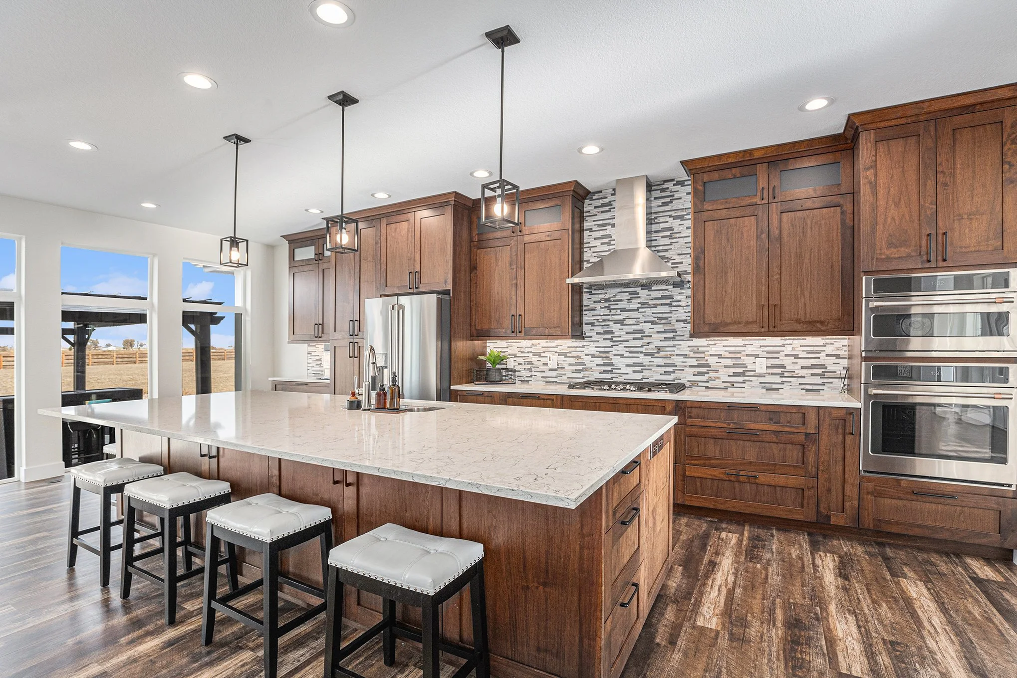 Updated kitchen with large island, wood cabinetry, and stainless steel appliances