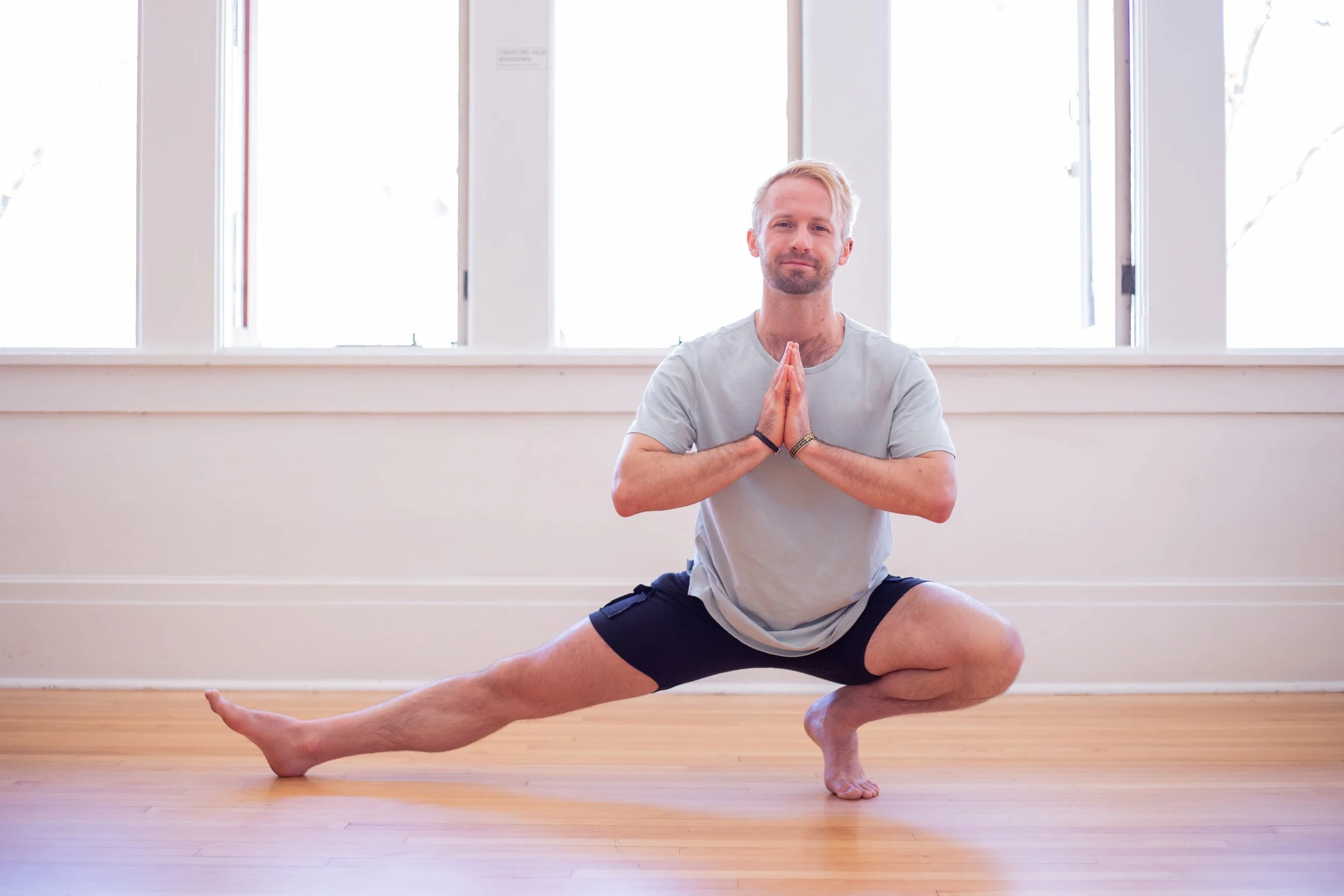 Adam Skyy practicing yoga in a bright studio in Salt Lake City