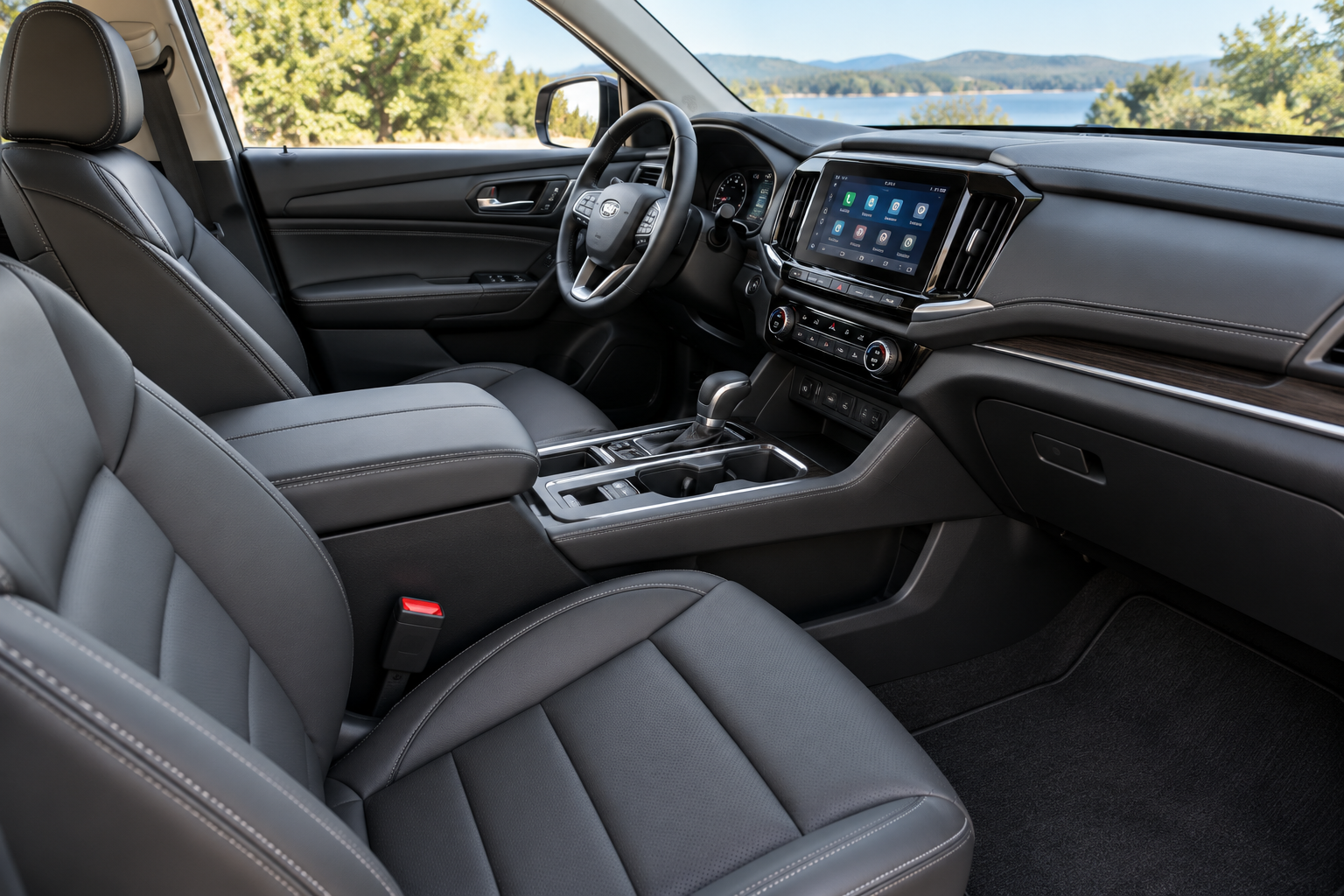 Interior of a modern vehicle, showing the driver's seat, dashboard, steering wheel, center console with gear shift, and a touchscreen display, with trees and water visible through the windshield.