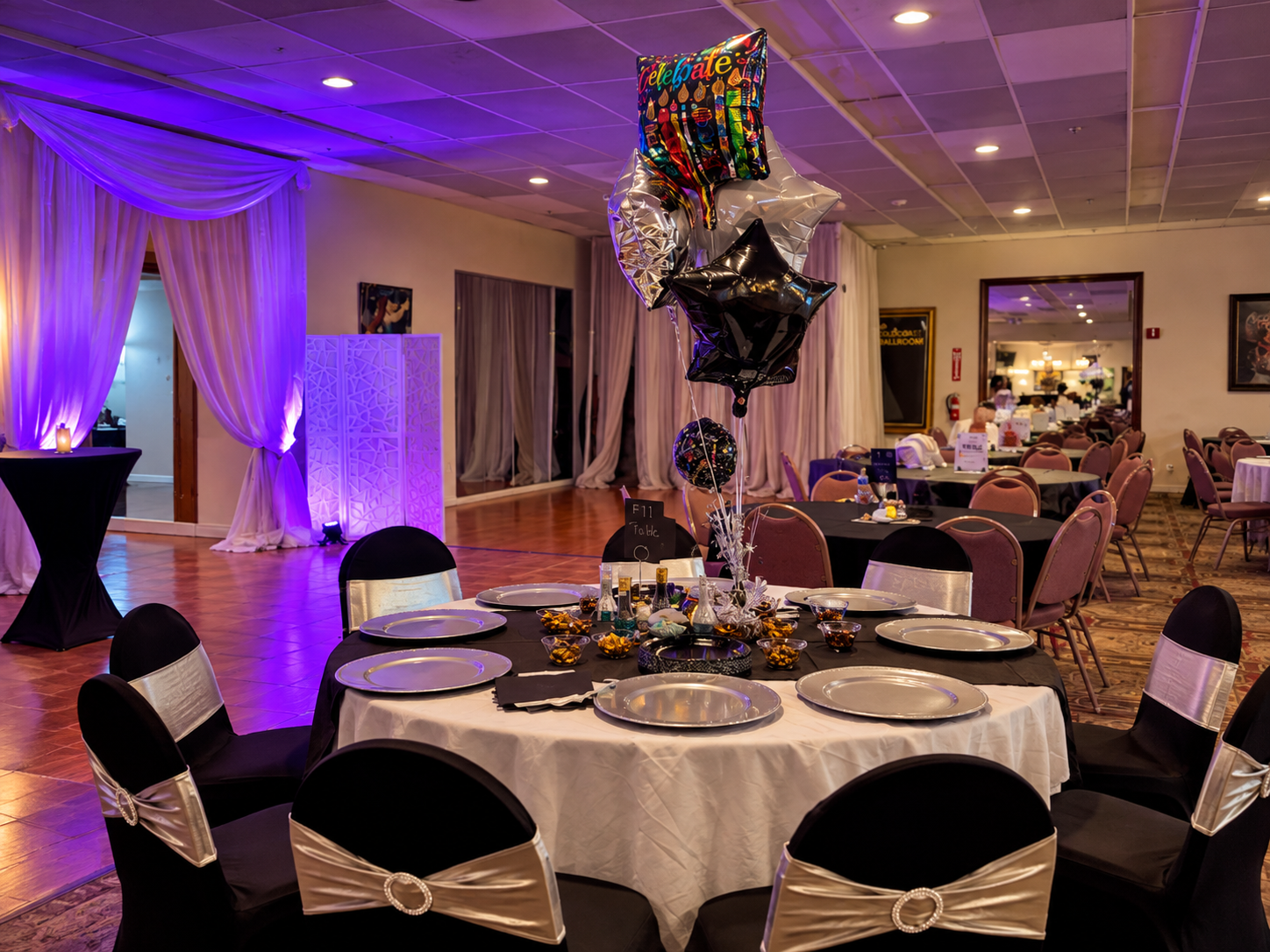 Party room decorated with balloons, including one that says 'Celebrate,' set for a celebration event.