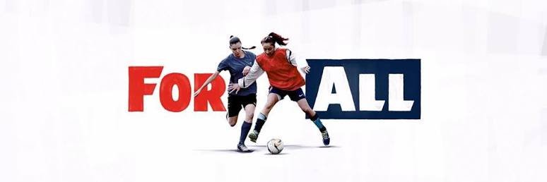 Two female soccer players competing for the ball in front of a 'FOR ALL' text background.