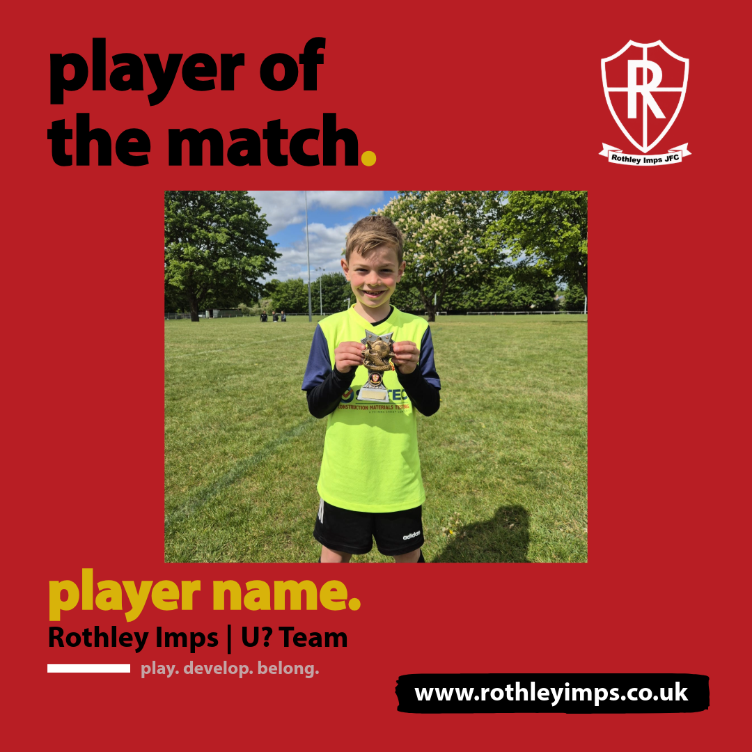 A young boy standing on a grassy field, holding a trophy and smiling. He is wearing a yellow and navy sports jersey with black shorts. The background features trees and a partly cloudy sky.