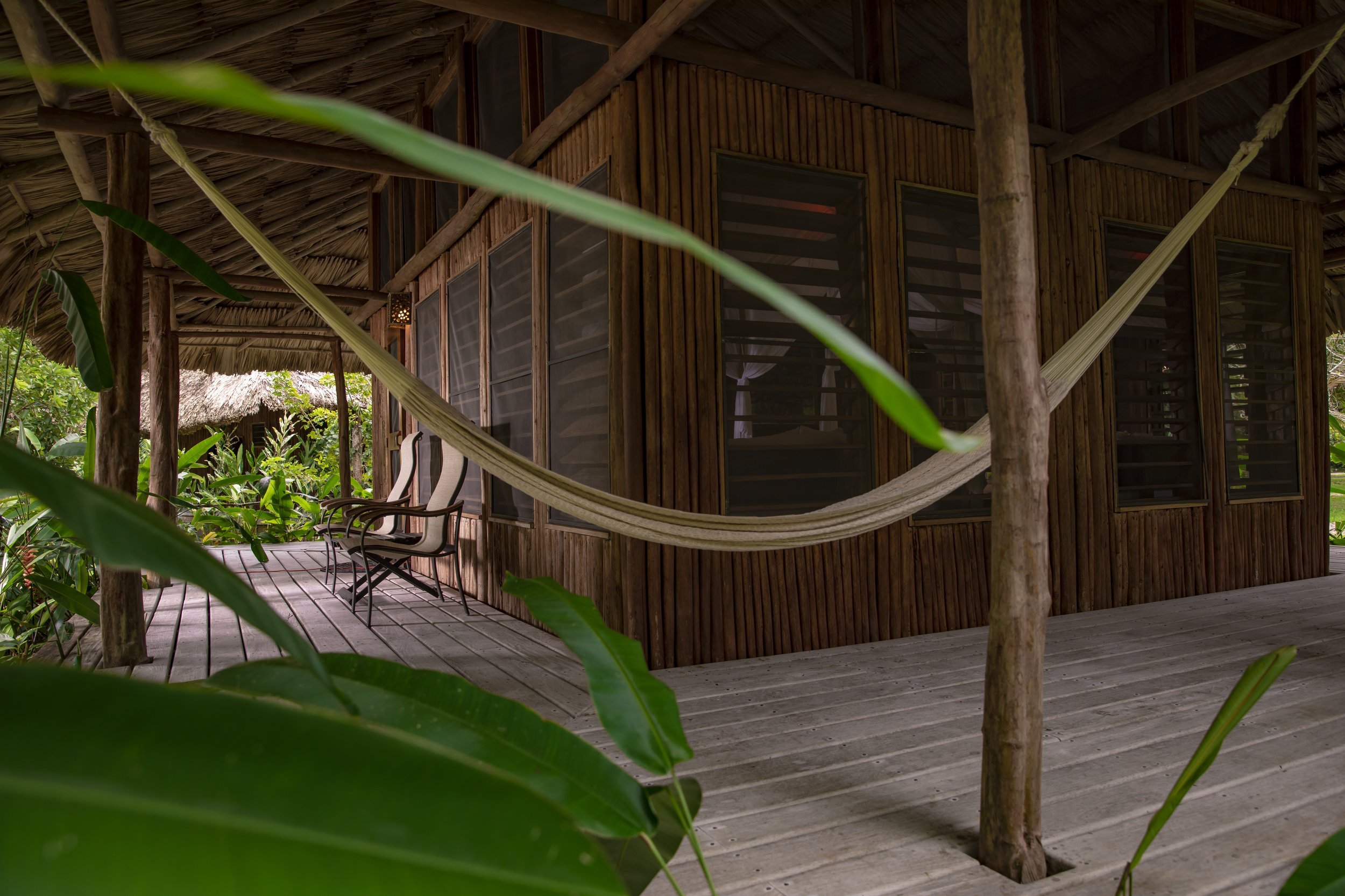 Wooden veranda with a hammock, beneath the eaves of a raised timber building