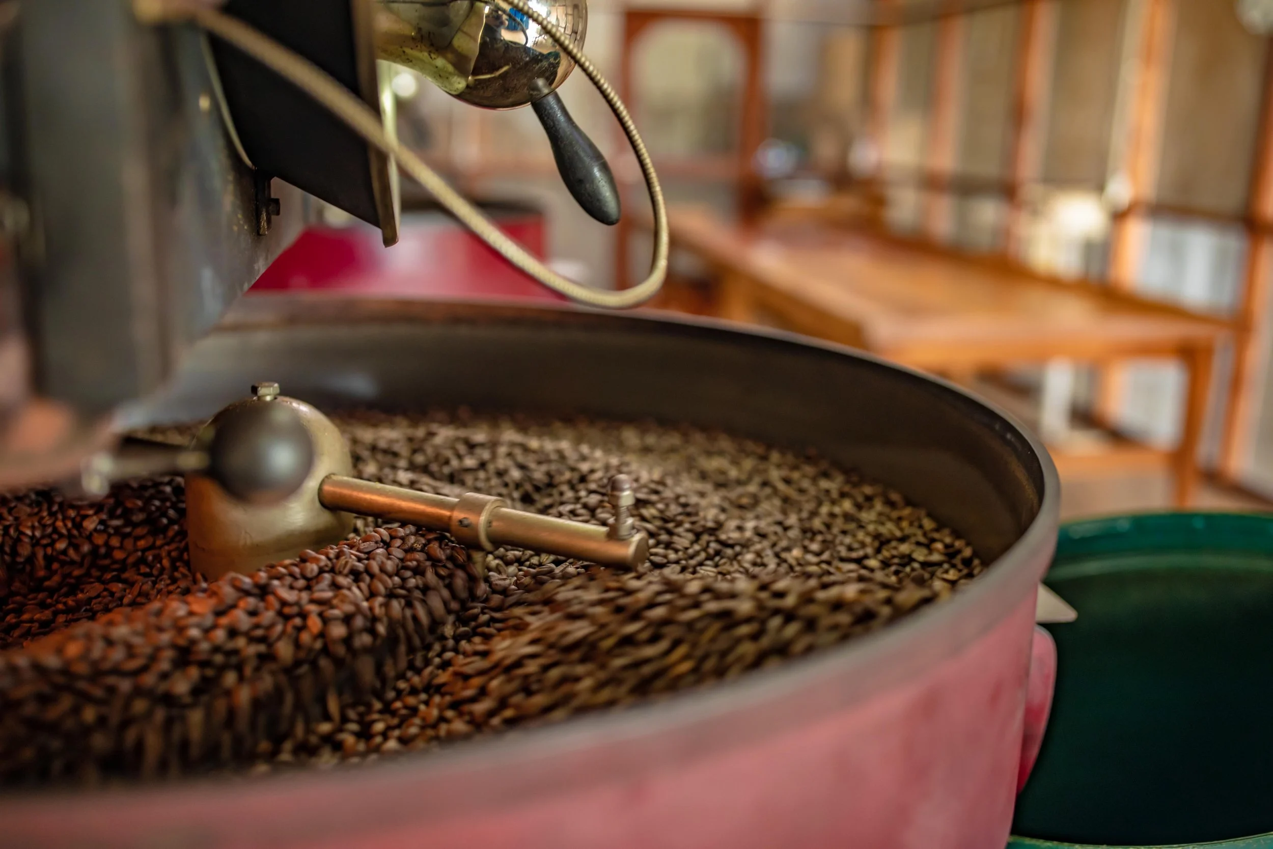 Coffee beans being roasted in a large industrial coffee roaster.