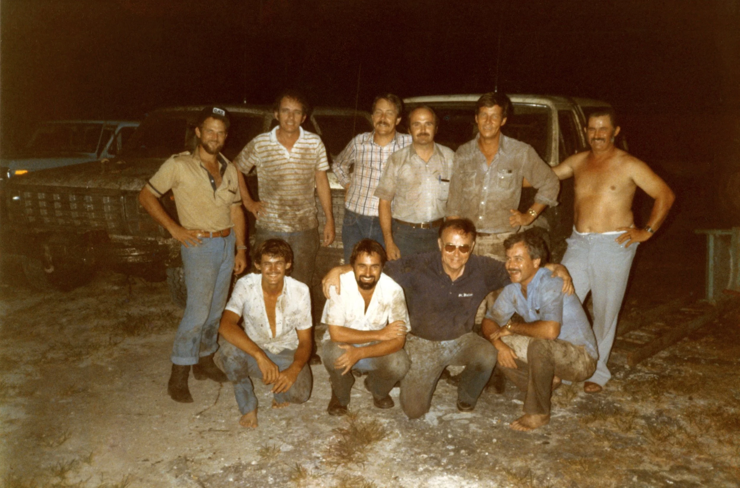 Archive photo of a group of men posed together at night, the front row kneeling