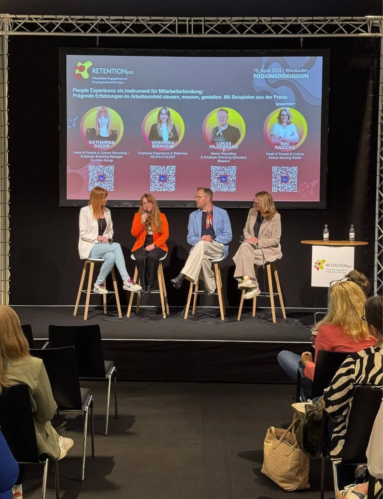 Podiumsdiskussion bei der RETENTIONpro Messe in Wiesbaden, mit vier Panelisten und Publikum im Saal.