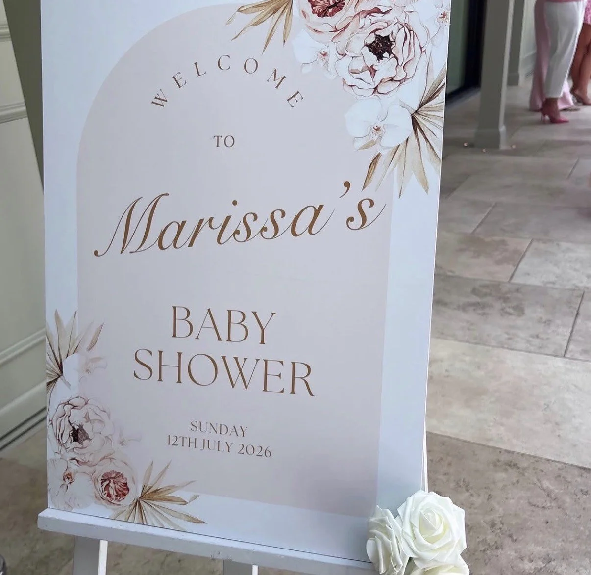 Welcome to Marissa's baby shower sign with floral decorations, dated Sunday, 12th July 2026.