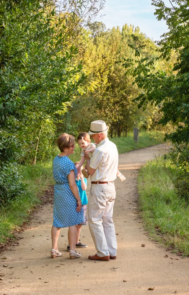 A family of three enjoying a walk on a dirt path