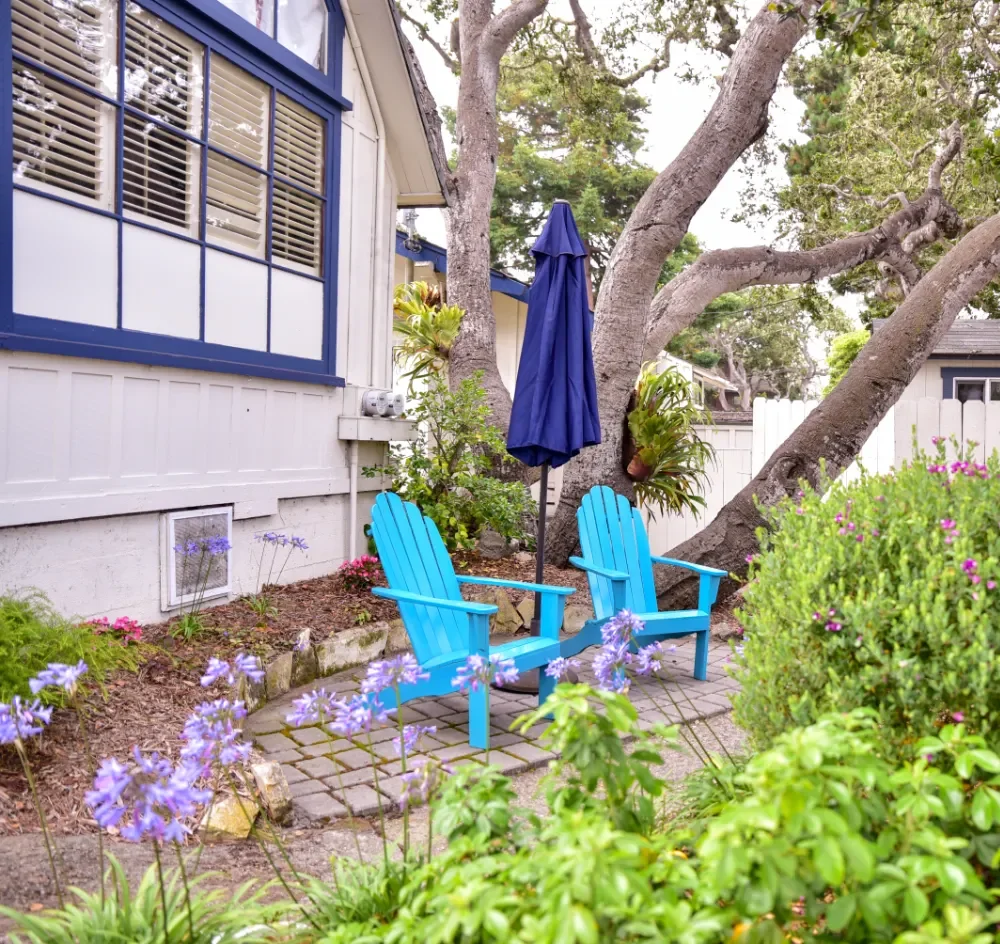 A cozy garden with blue Adirondack chairs