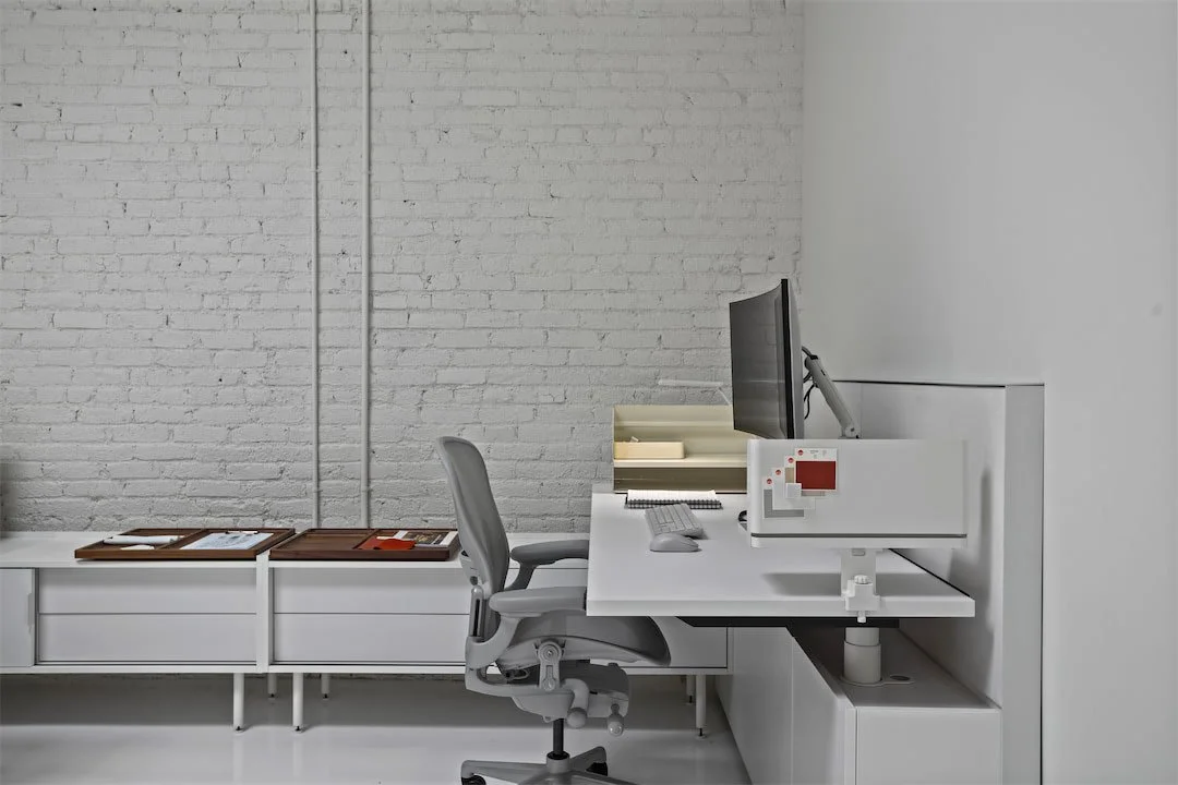 Integrated workstation against a painted brick wall at Pivot Interiors