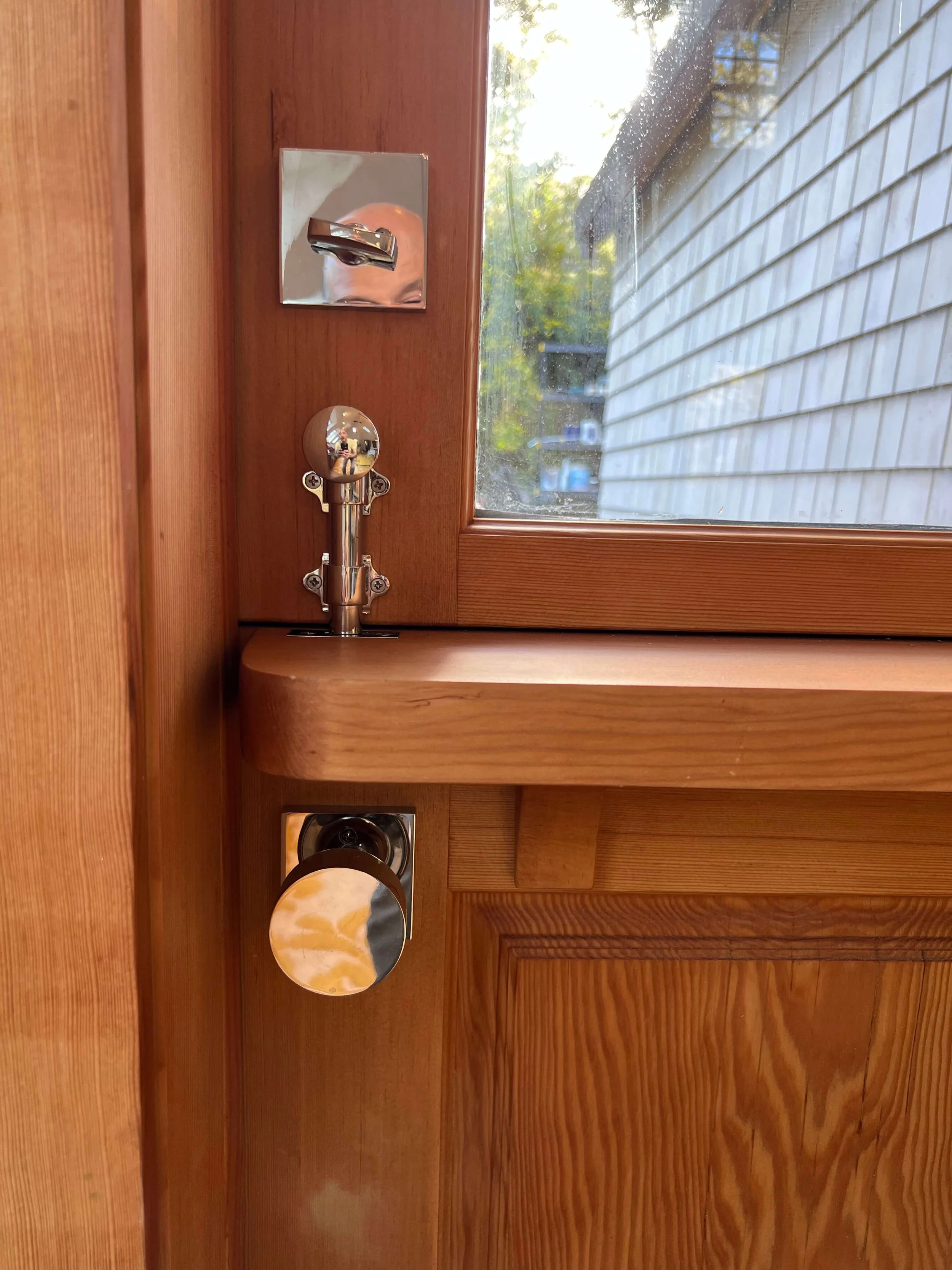 Traditional polished dutch door hardware and restored wood detailing at the Saltbox house