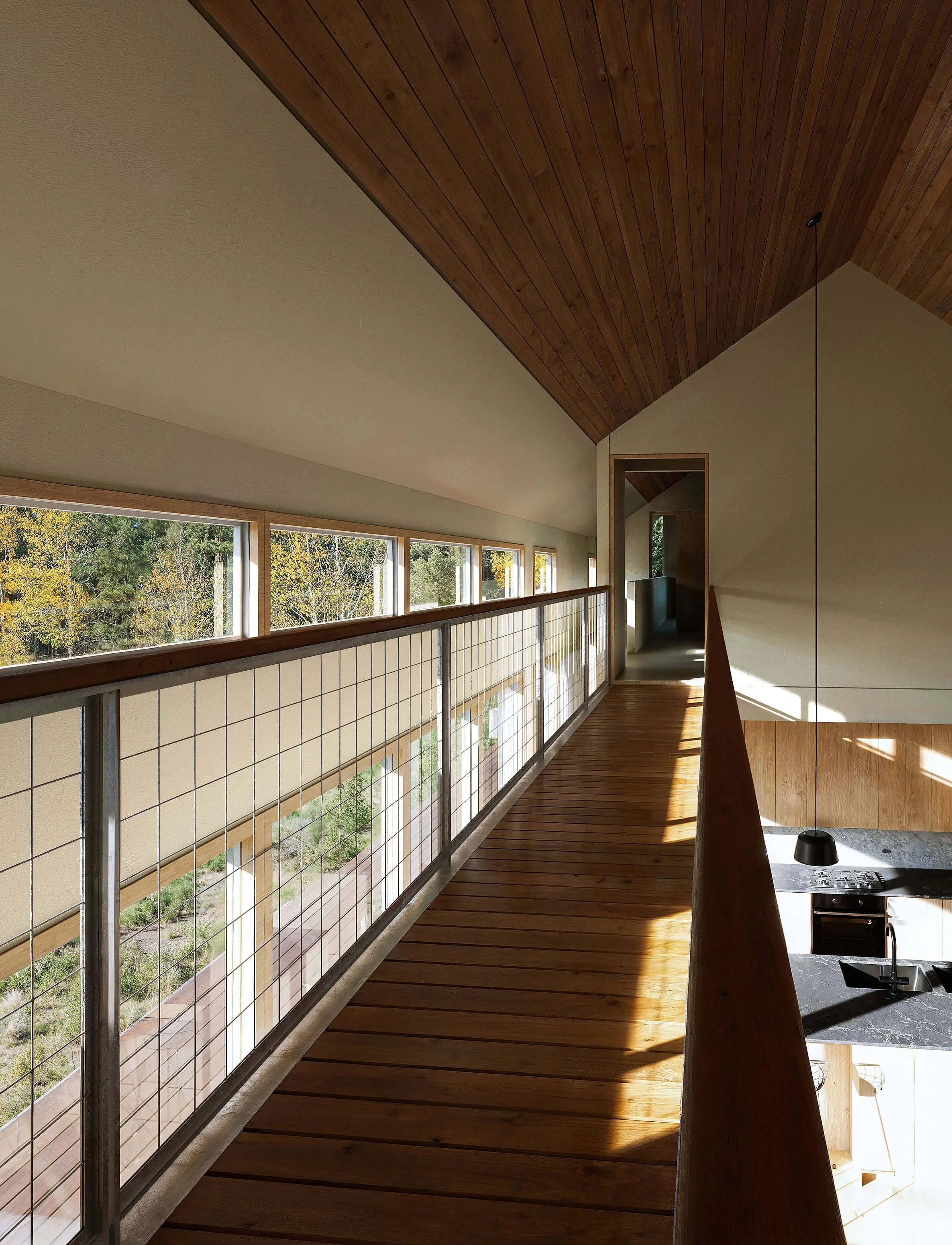Upper-level bridge overlooking the double-height living space at Big Wood River Ranch