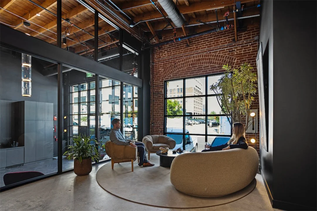 Informal lounge beside a large industrial window in the historic Pivot Interiors building