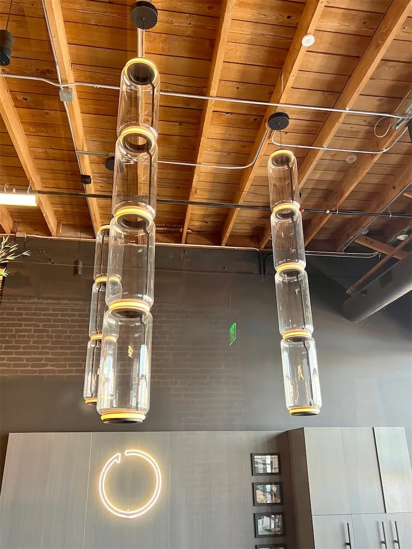 Glass pendant lights suspended from the exposed timber ceiling at Pivot Interiors