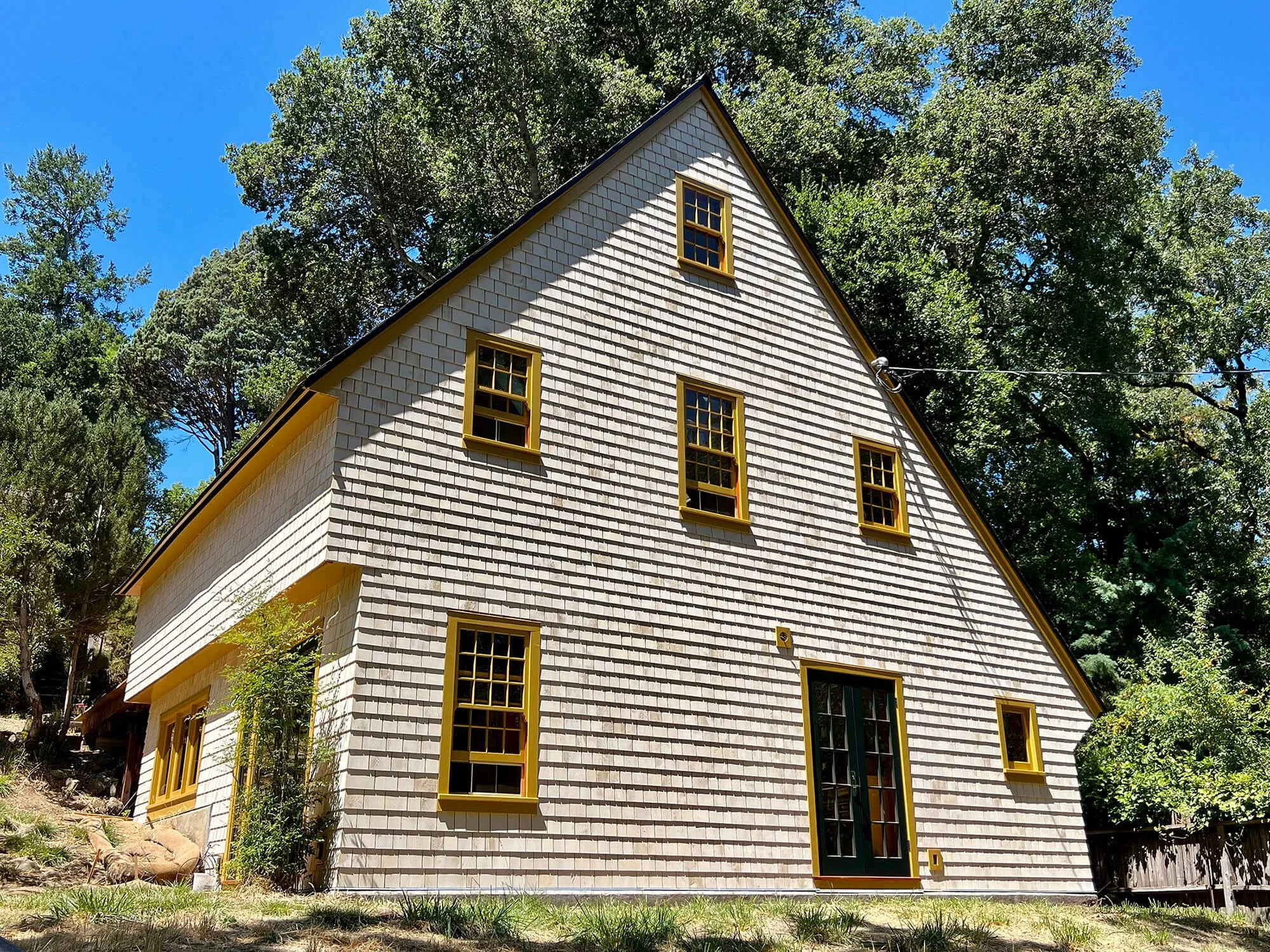 Restored West Marin saltbox house with new white cedar shingles and renewed wood windows