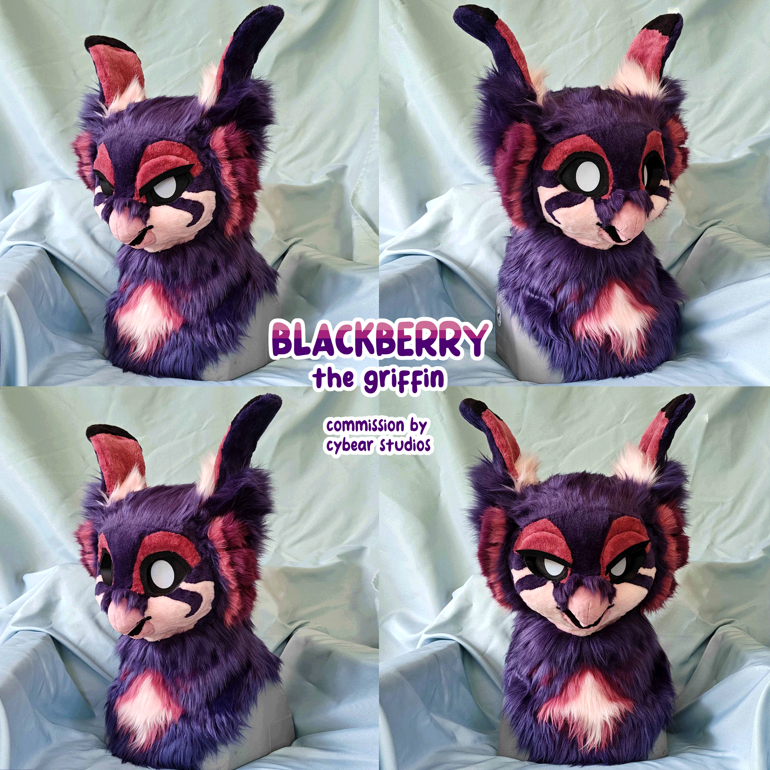 Side view of a purple, pink, and black fursuit head resembling a feline character with large eyes, upright ears, and a detailed face, placed on a light-colored fabric background.