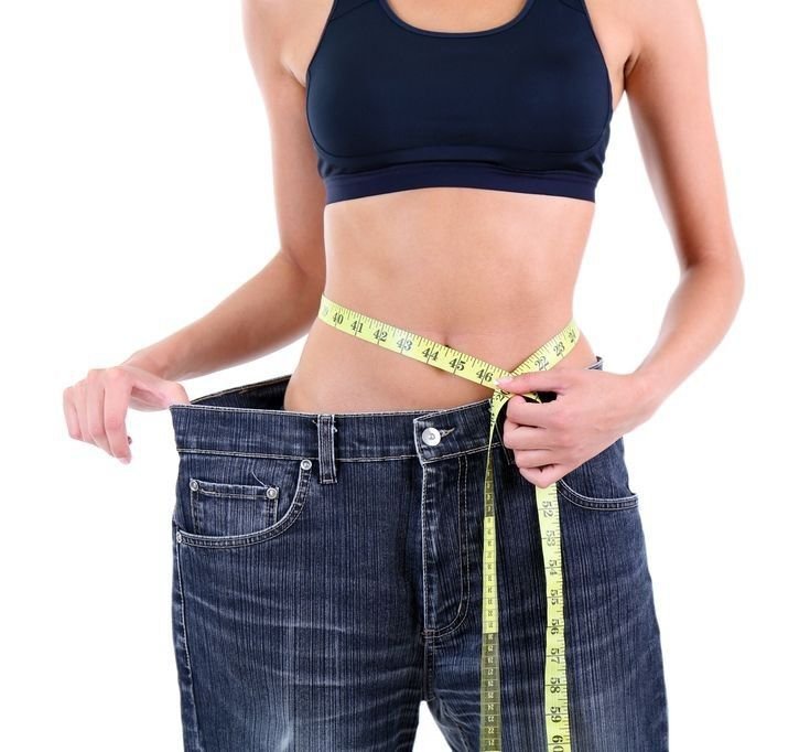 Woman measuring her waist during a medical weight loss journey.