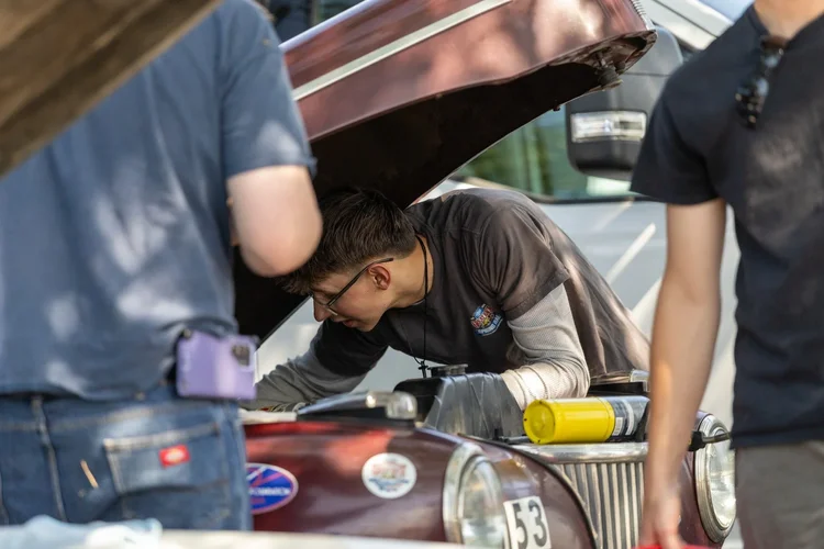 X-Cup student working under the hood of a Great Race vehicle