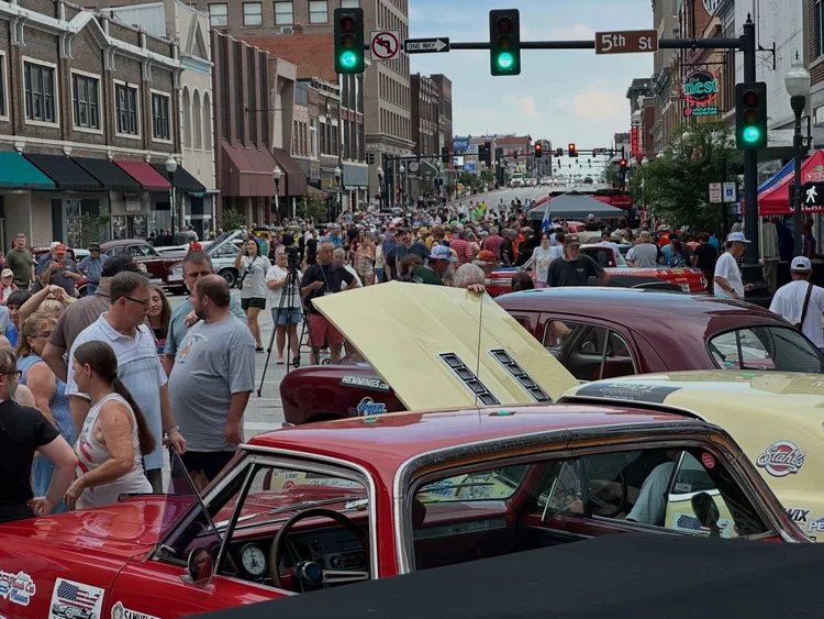 Historic Great Race cars in a downtown setting