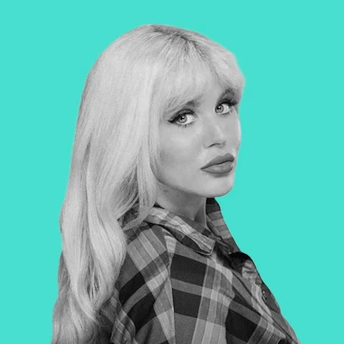 Black and white photo of a woman with long blonde hair wearing a plaid shirt, set against a turquoise background.