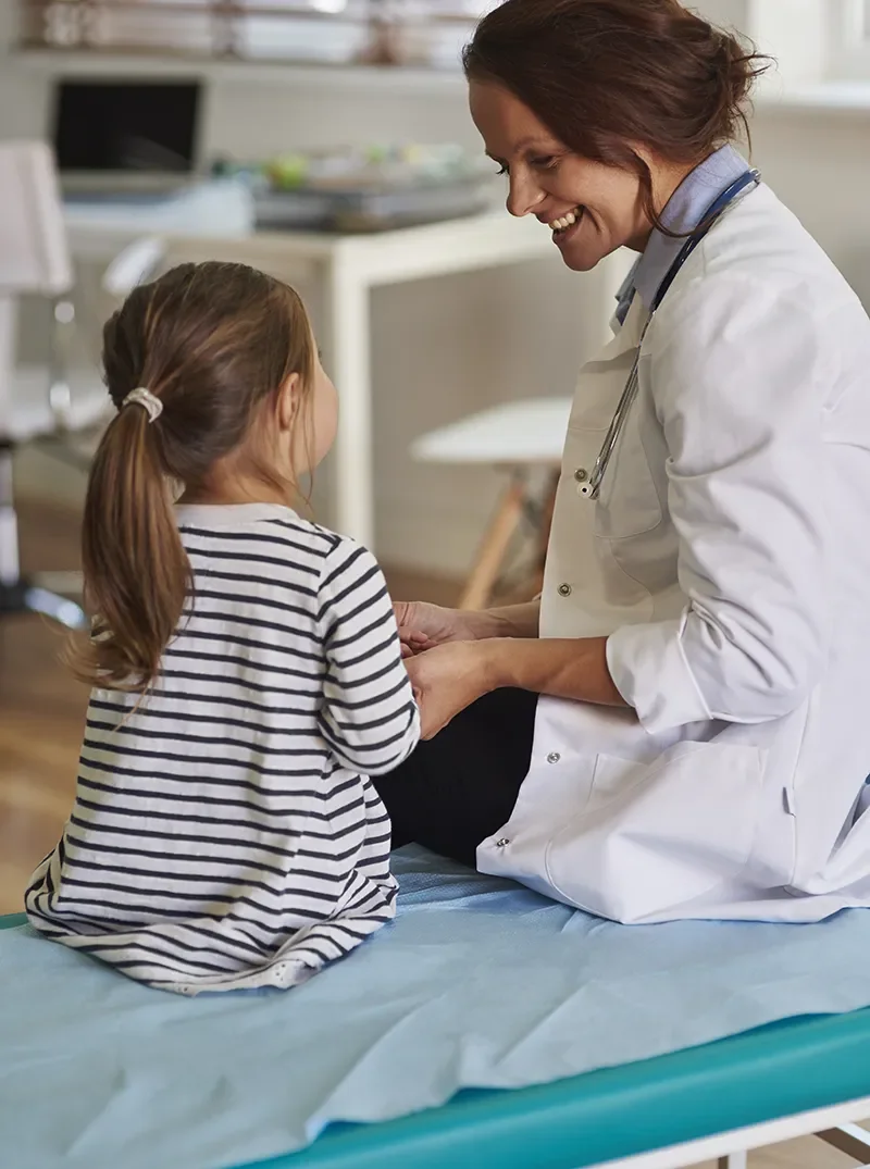Provider smiling with a young girl during a checkup