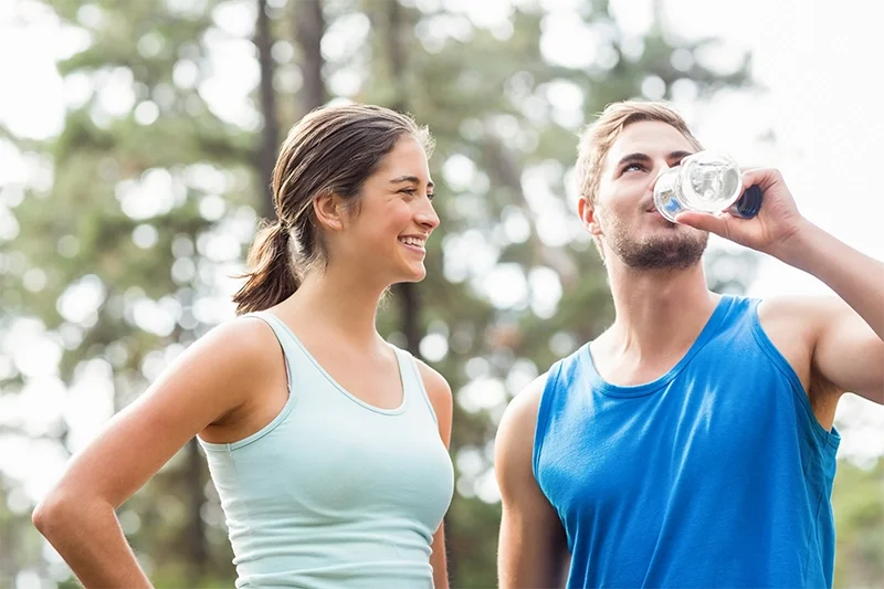 A young woman and man outdoors, smiling receiving hormone optimization consultation in Redding, CA