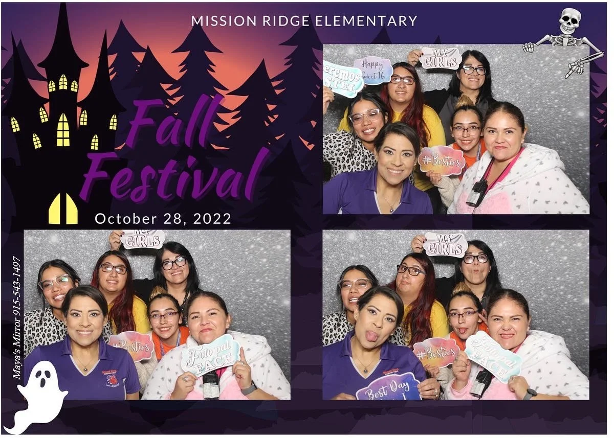 Group of six women at a Halloween-themed photo booth during a fall festival at Mission Ridge Elementary on October 28, 2022. They are holding various signs with messages like 'My Girls,' '#Besties,' 'Fierce & Face,' and 'Best Day.' The background is sparkly gray. There are Halloween and spooky-themed decorations, such as a ghost and a skeleton, and a purple house with glowing windows, set against a dark silhouette of trees and a sunset sky.