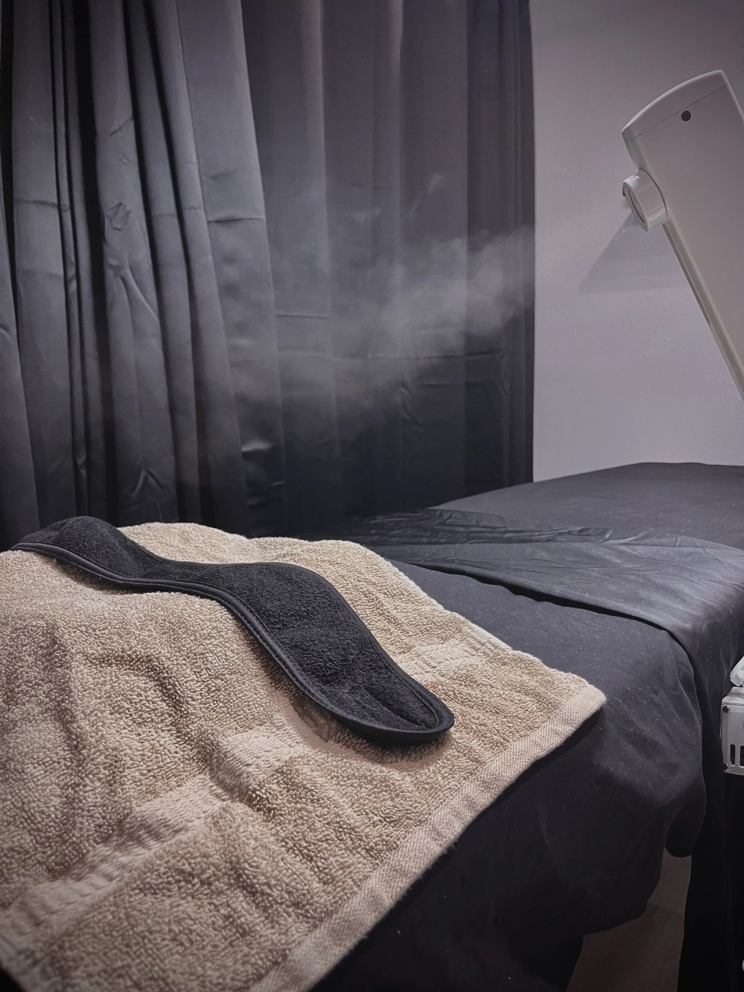 A facial bed set up with a steamer going