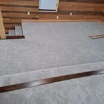 A staircase with gray carpeted steps and wooden railings in a room.