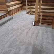 Interior view of a staircase with carpeted steps and wooden walls.